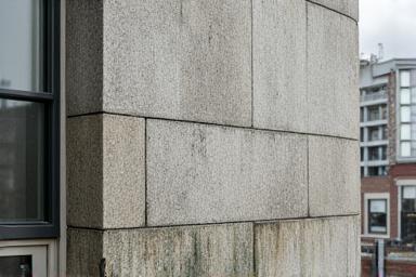 Dull and dirty granite building facade before cleaning